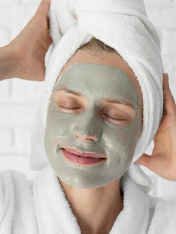 A woman with her face covered in homemade French green clay facial mask.