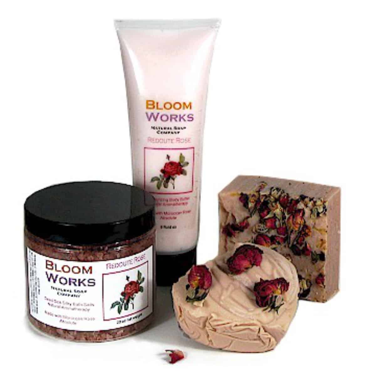rose attar cold process soap with rose petals on top with matching bath salts and lotion.