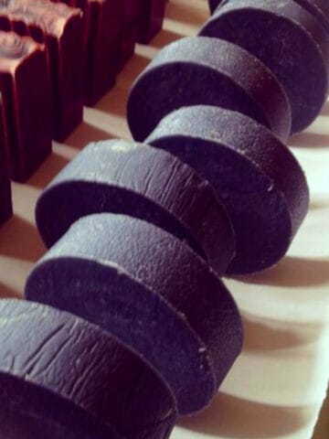 round Hockey puck charcoal soaps curing in a row.